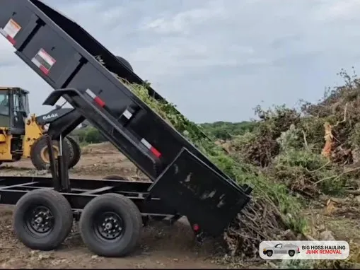 Dump trailer tipping out a load of brush