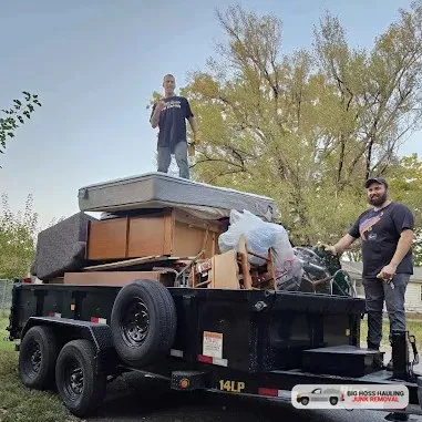 Crew with a trailer piled high with mattresses and furniture