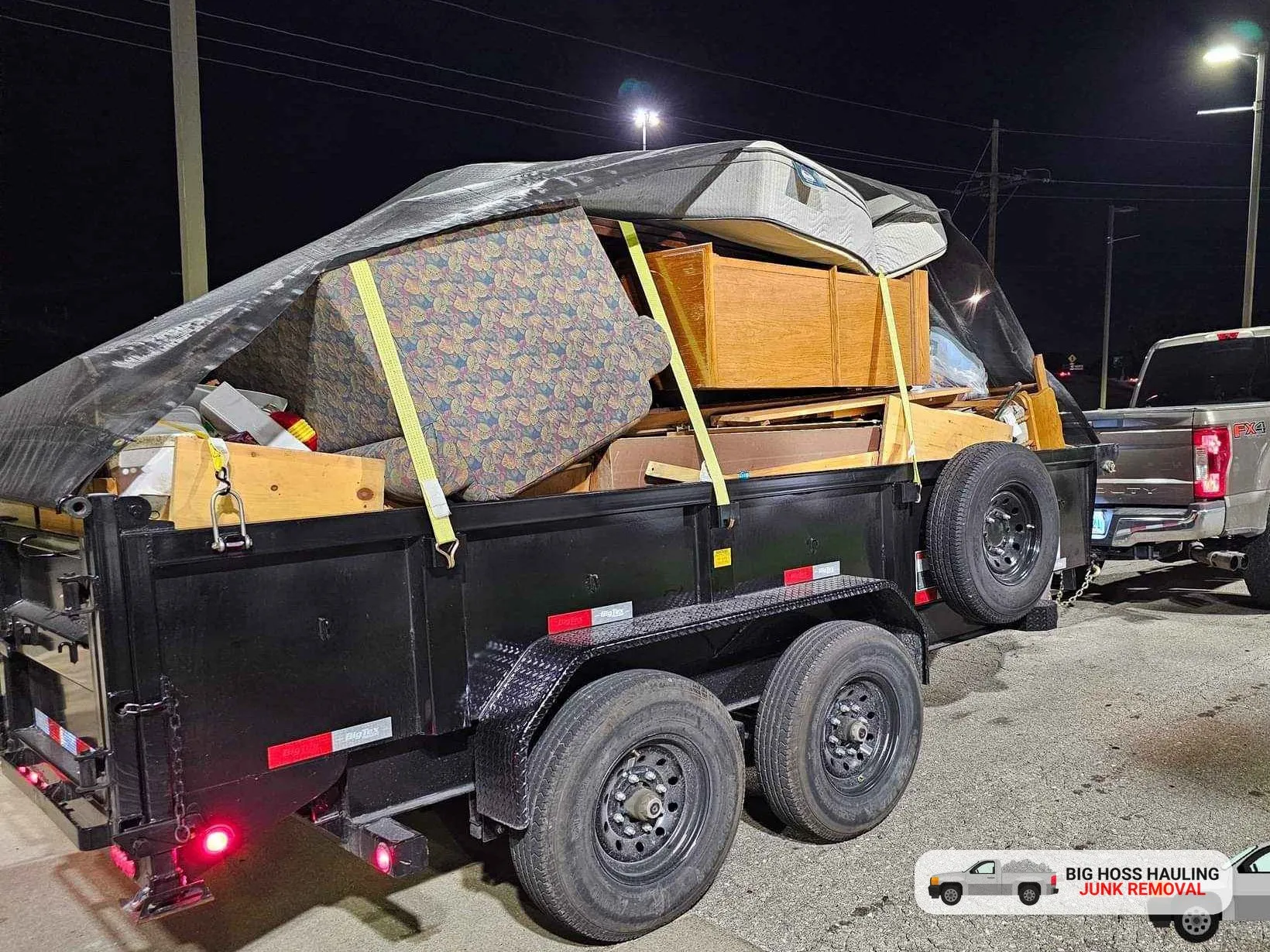 A full trailer of furniture strapped down at night